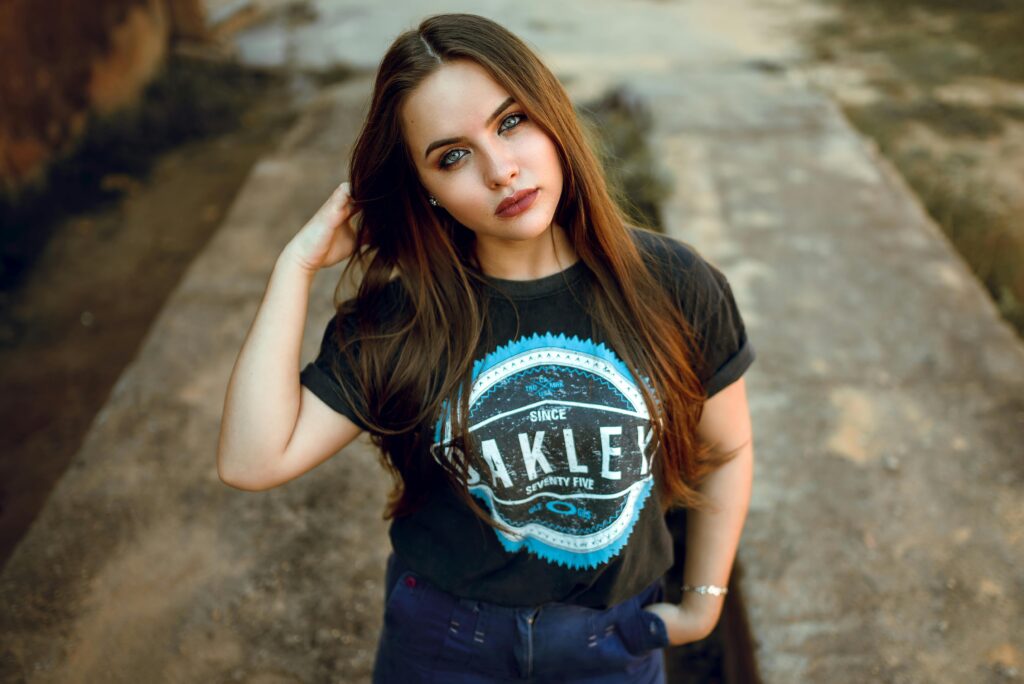A young woman with long brunette hair poses confidently outdoors in casual attire showing webbolt money stream.