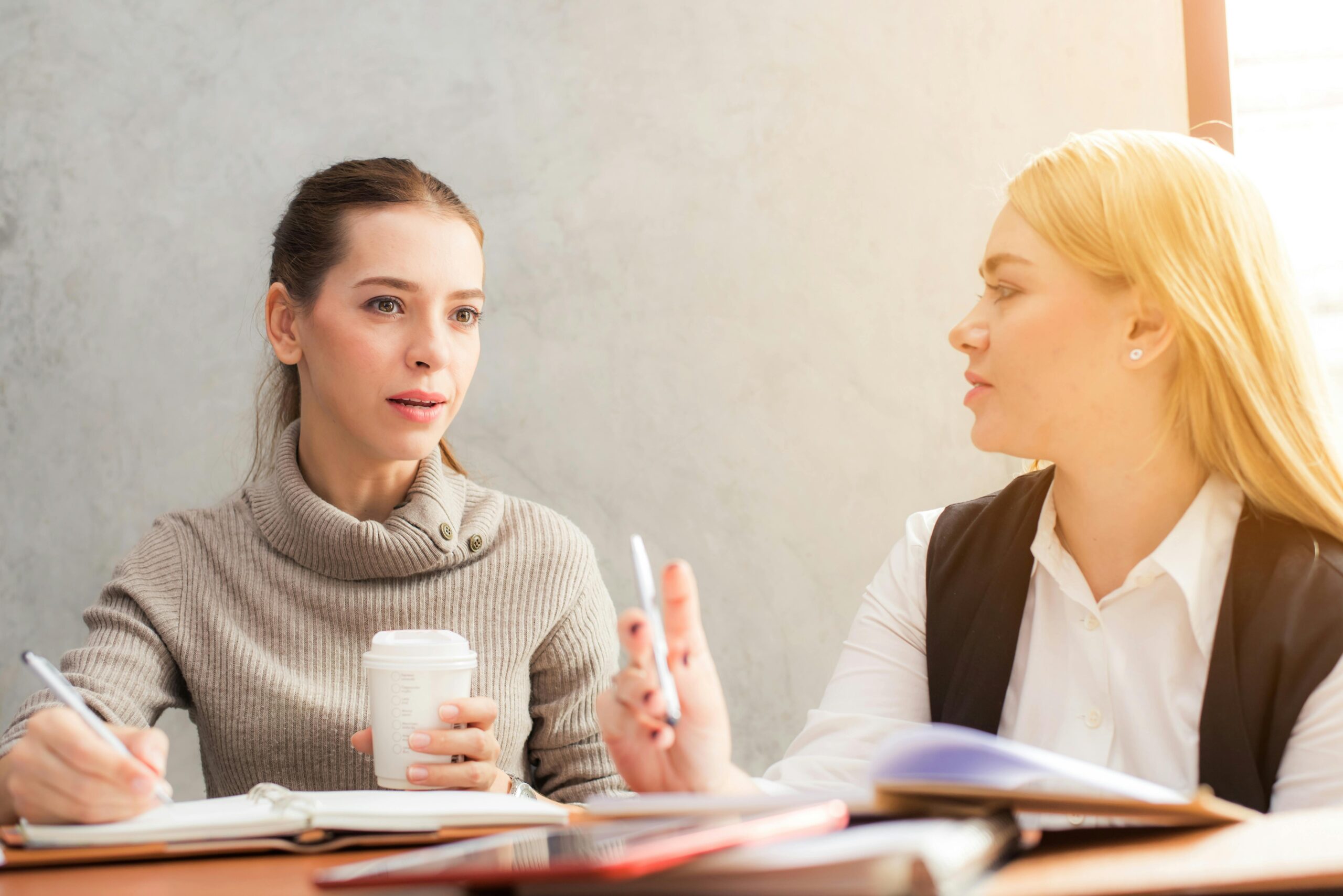 Two women engaging in a professional conversation about difference between affiliate marketing and digital